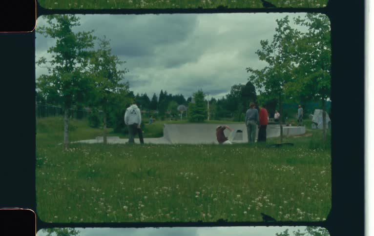 A guy skateboarding inside a skateboard dome at a park while people watch