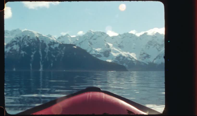 Boat on a lake near the snow covered mountains at morning
