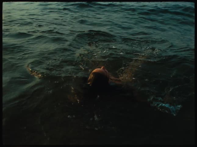 Woman in a red bikini floating in the middle of the sea