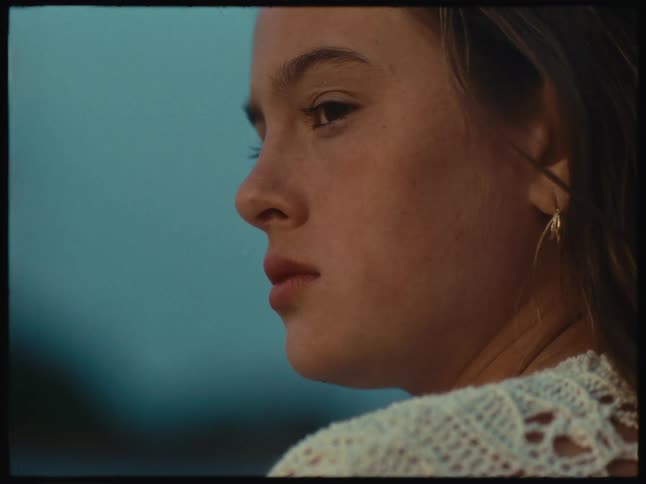 Face of a girl in a white dress looking at the sunset