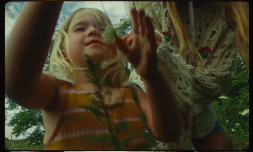 A little girl and a teenage girl with flowers in their hands and the little girl is happy