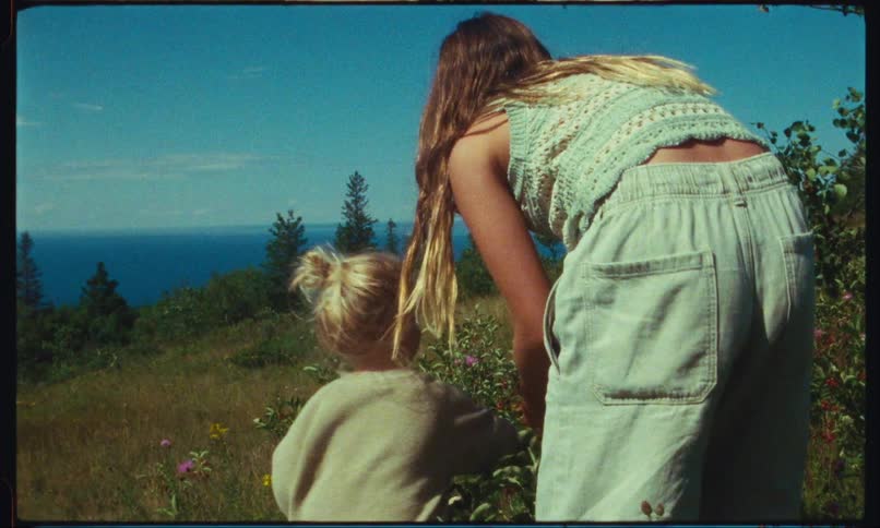 Mother and daughter picking wildflowers in the mountains