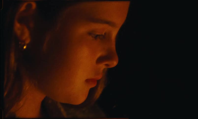 A teenager is sitting by the campfire