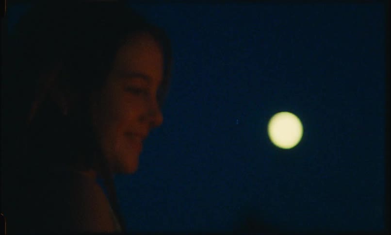 A girl is laughing outside at night