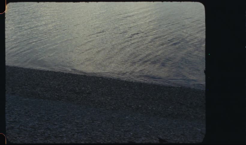Waves roll into shore and over pebbles on the beach