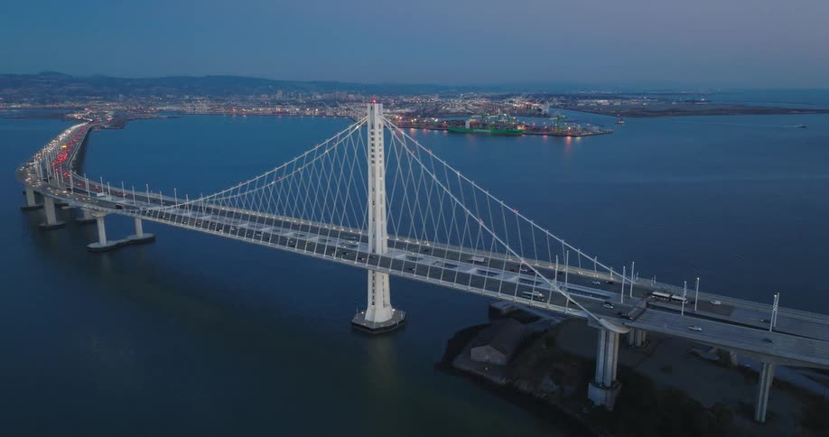 A huge suspension bridge in the sea and several cars passing over it