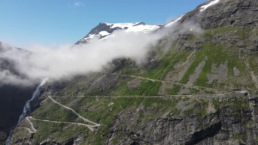 Panorama of a mountain range and valley covered in snow on a day with a blue sky