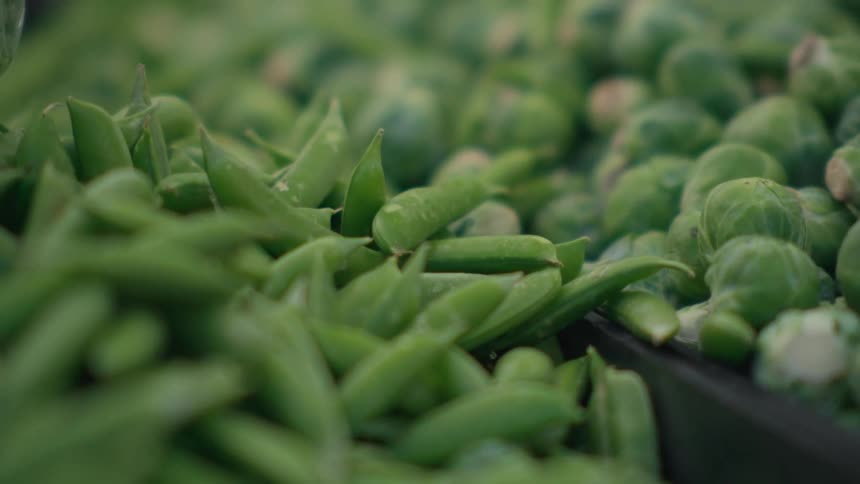 A closeup of fresh green peas and brussels sprouts