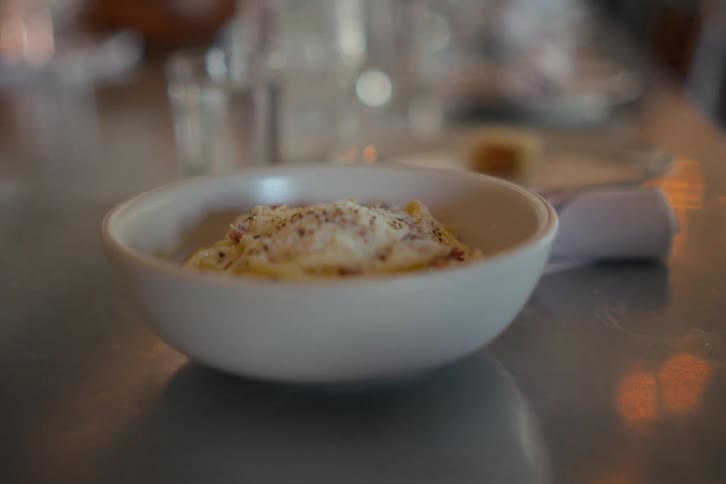 A bowl of food being served on a long table