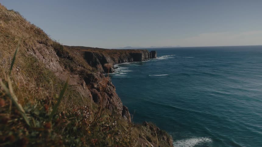 A serene scene of cliffs on the coast next to the ocean