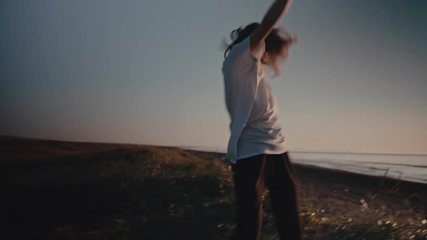 A girl does a somersault on the shoreline