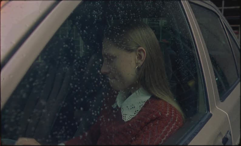 Sad woman crying in her car on a rainy day