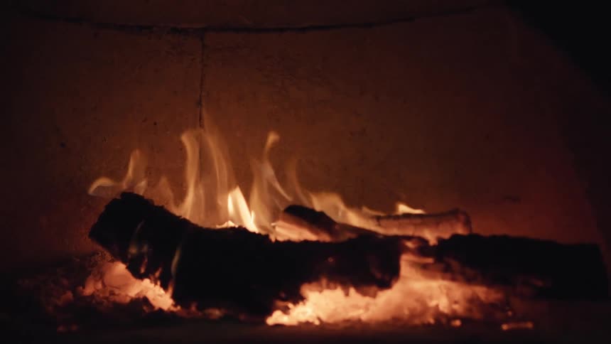 Flames from a fireplace lit at night