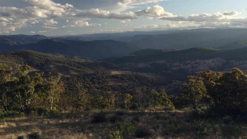 Two people looking at a peaceful landscape of valleys and mountains at morning