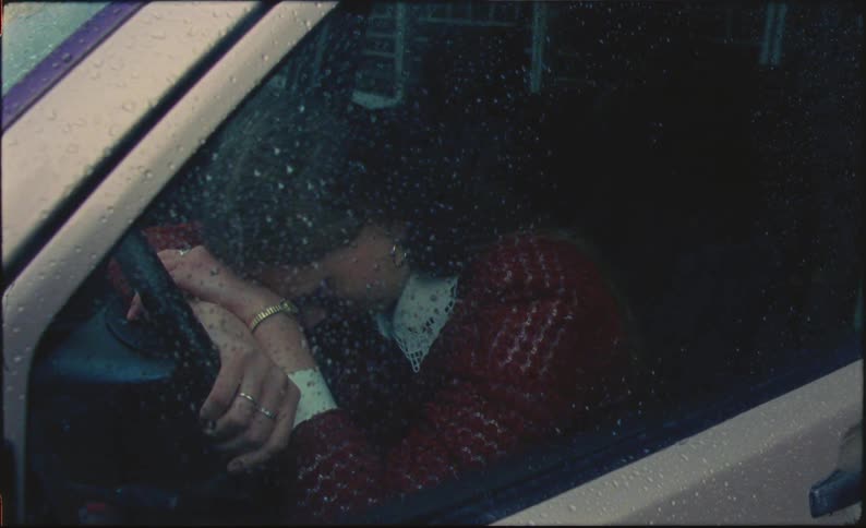 Sad woman crying in her car on a rainy day