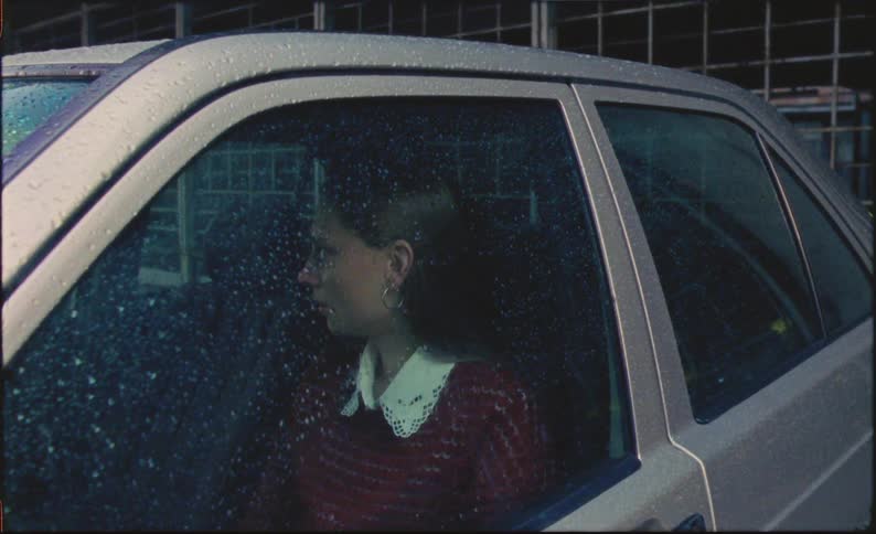 A woman sitting in her car crying and looking stressed out
