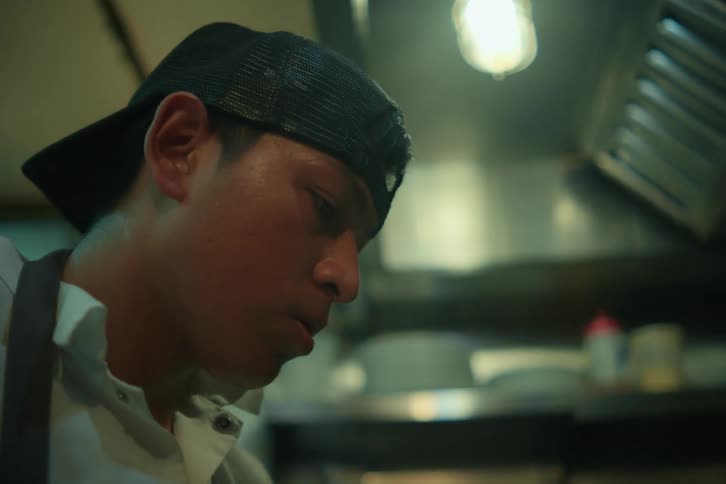 A man is cooking in the restaurant