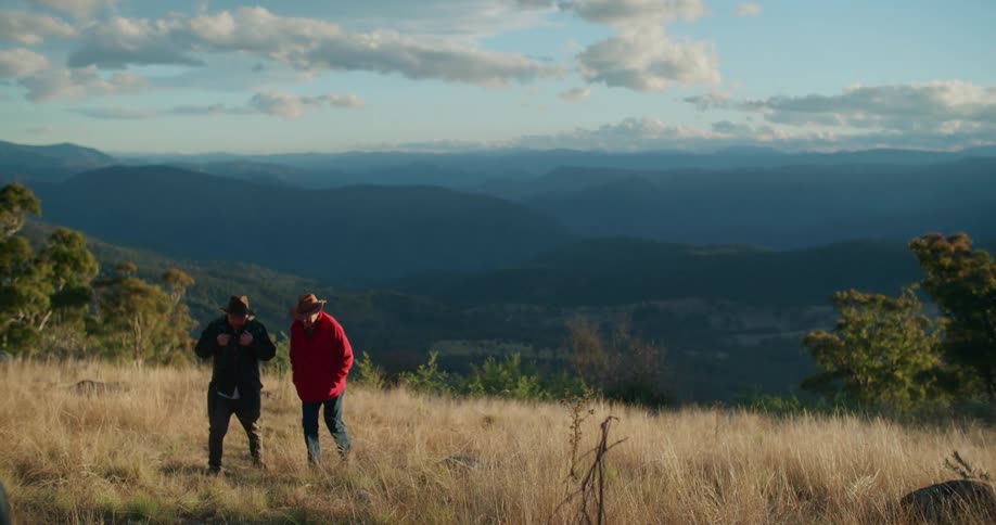 Two men walk through the meadow during the cold day