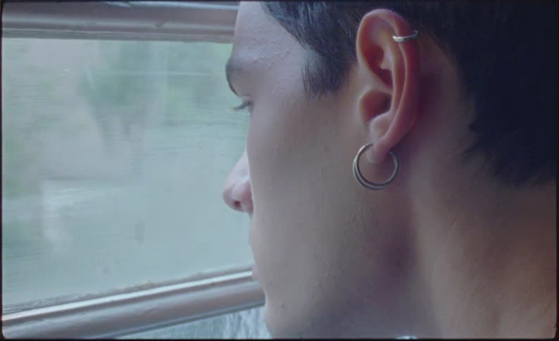 A sad man looking at the landscape through the window
