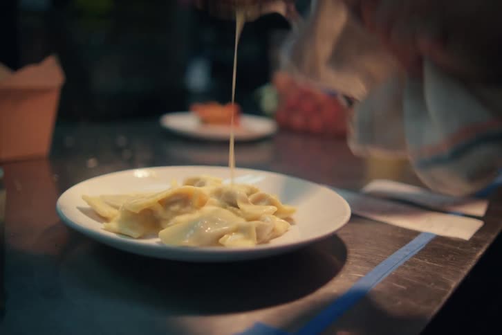 A man pours food from the pan on the plate