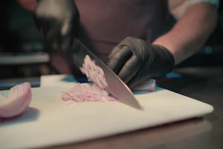 A person cutting ingredients for a meal