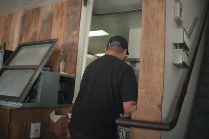 A man takes two boxes and enters through a door