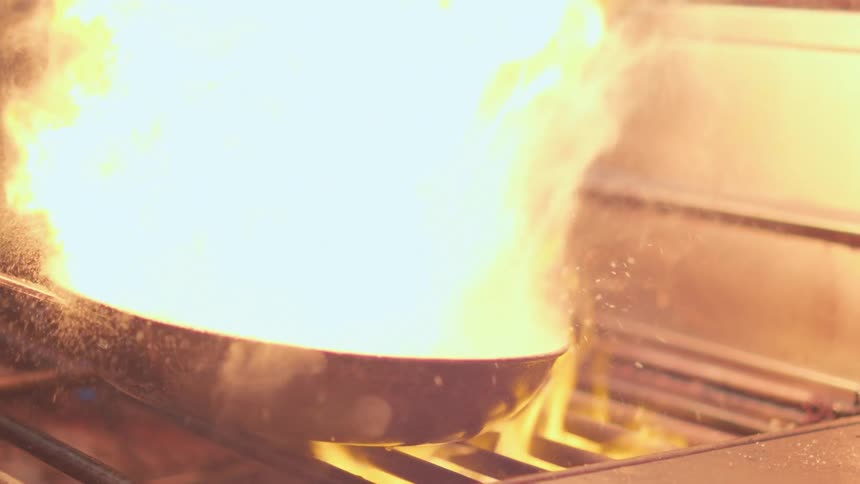 Water falling into a hot pan and flames come out of the pan