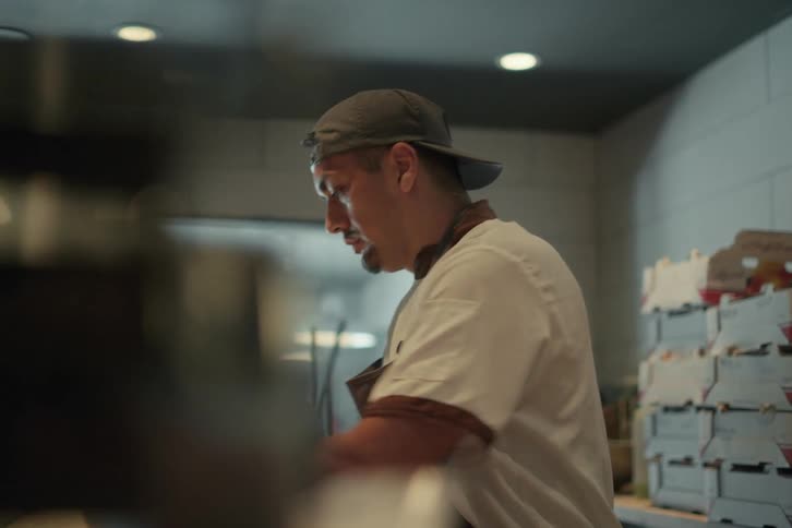 Restaurant worker cuts and weighs pieces of dough in kitchen