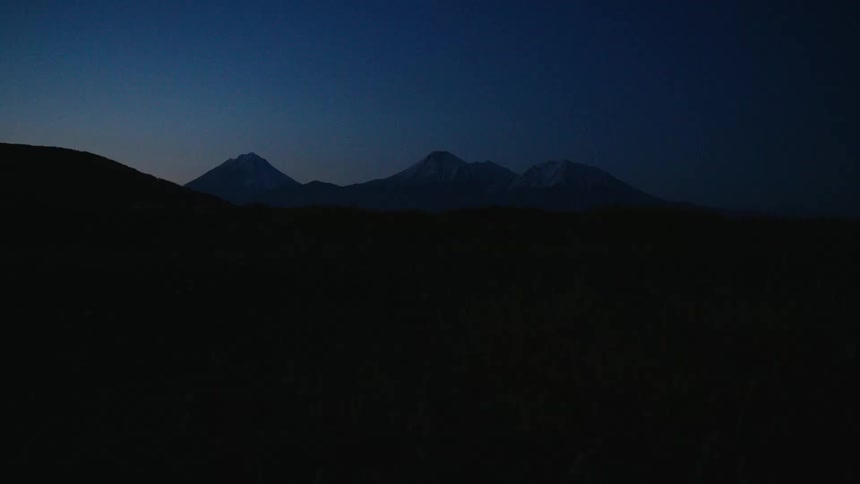 A view of some mountains in the distance at sunset