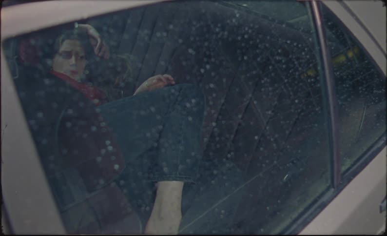 A woman lying on the seat of a car