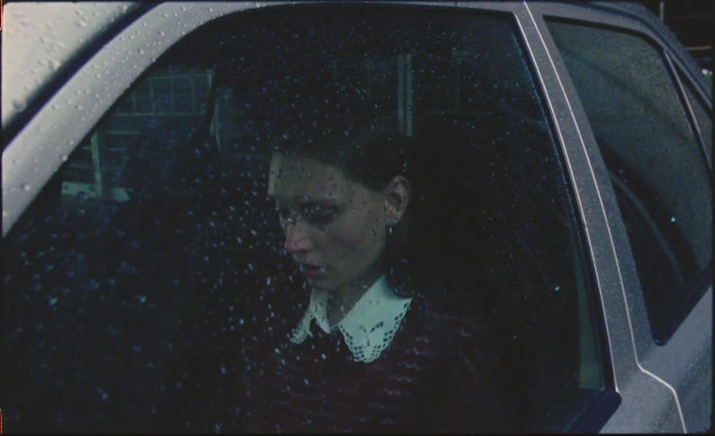 Close up of a sad woman in her car on a rainy day