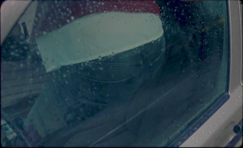 Barefoot woman steps over the drivers seat of a car to sit in the backseat