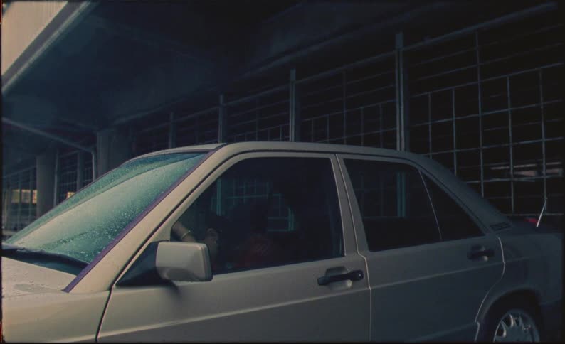 A sad woman in a parked car while it rains