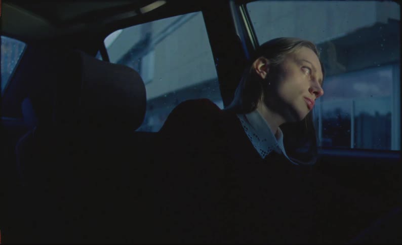 A sad woman talking to herself inside her car