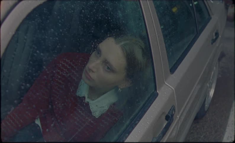 Sad woman crying in her car on a rainy day