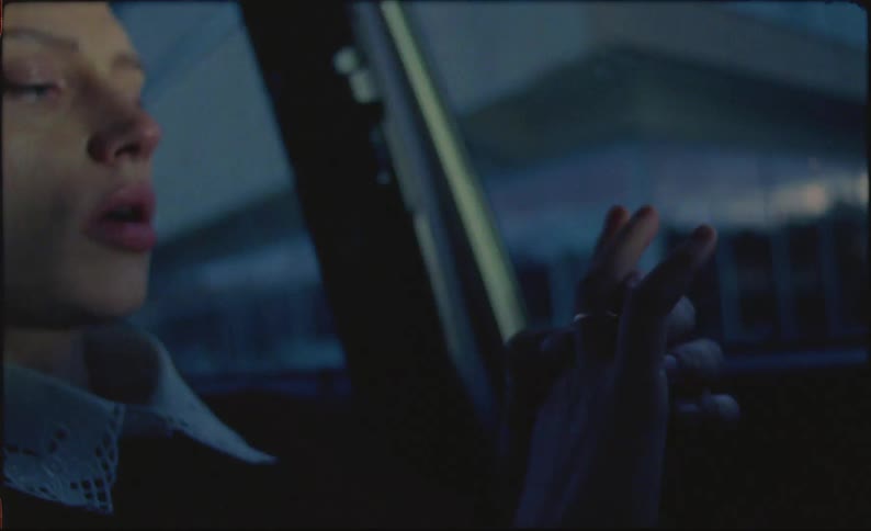 Close up of a young woman talking to herself inside a car