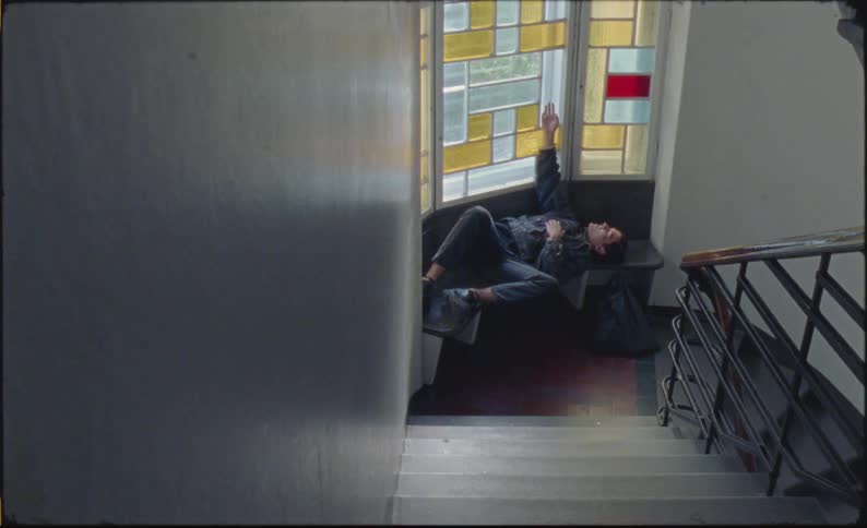 A clip of a person laying on a chair beside the stairway