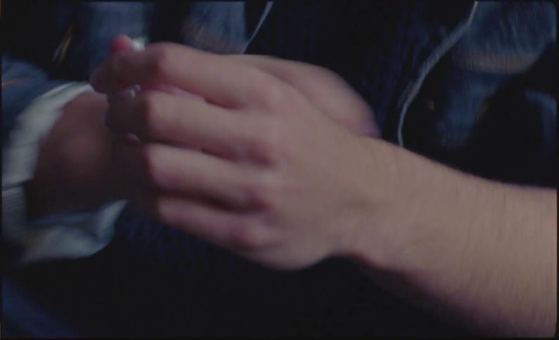 Young man uses a bent bottle cap to leave markings on his forearm