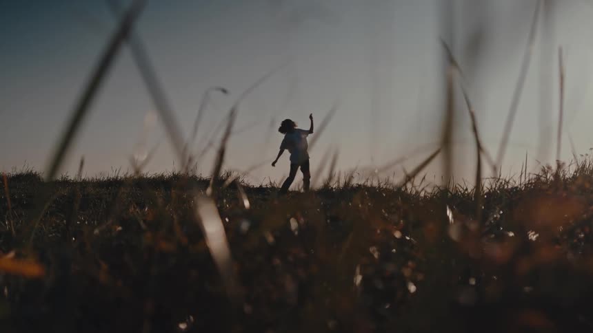 A woman is dancing on the grass