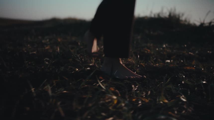 A person dancing in the field on a sunny day