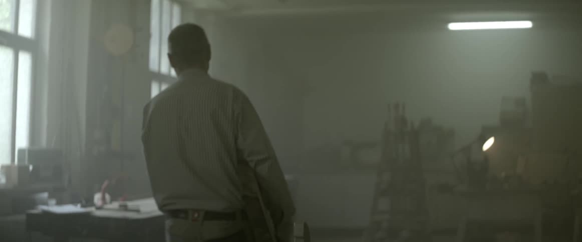 Man sets a large piece of wood on a table in a big workshop