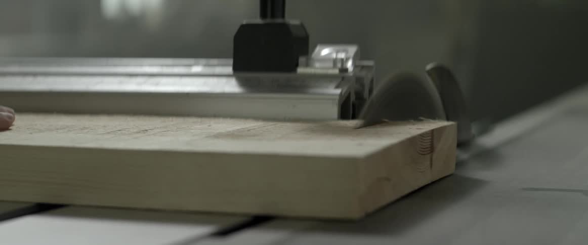 Wood is being cut on a table with a rotary blade