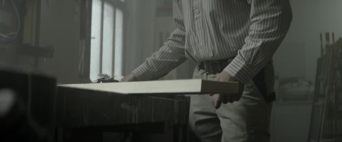 Man removing a clamp from a piece of wood