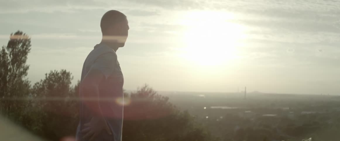 A man overlooks a valley on a sunny day