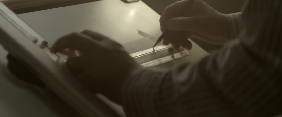 Man using a ruler to draw a straight line