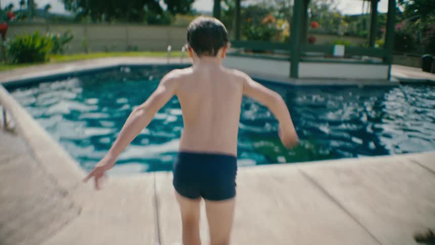 Boy makes a big splash jumping in the pool