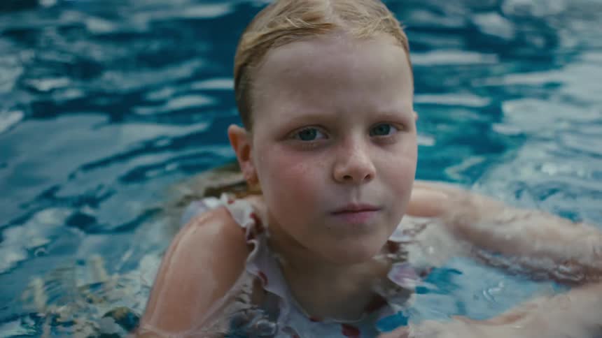 A girl swimming in the pool on a sunny day