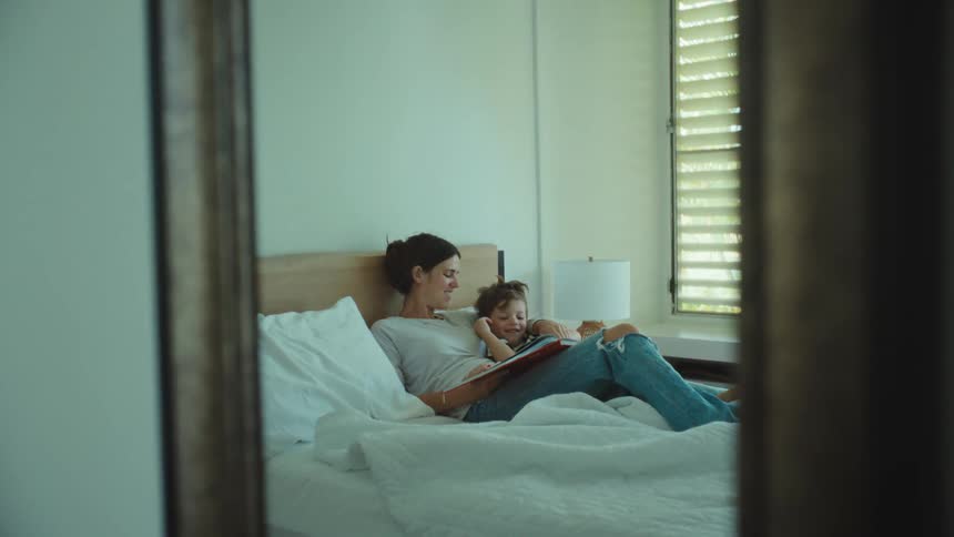 A mother and son sitting around reading books