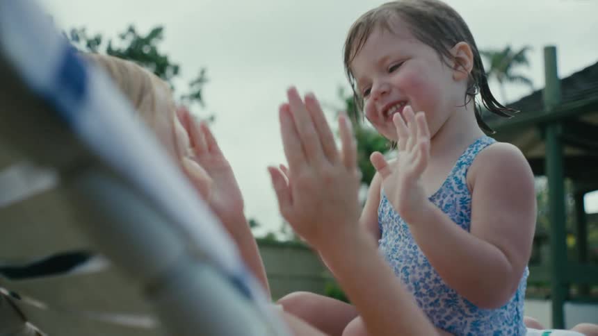 Sisters playing hand clapping games next to the swimming pool