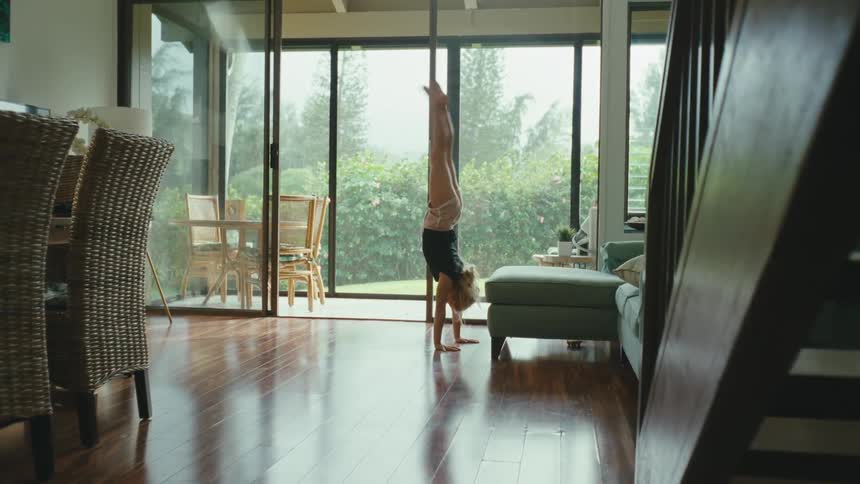 A girl does a flip on the couch